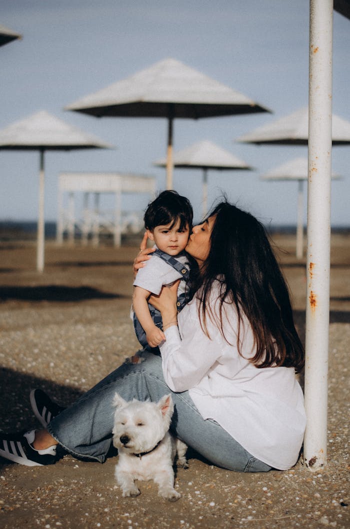 Services Mother kisses child by the beach with dog in Baku, capturing a warm family moment.
